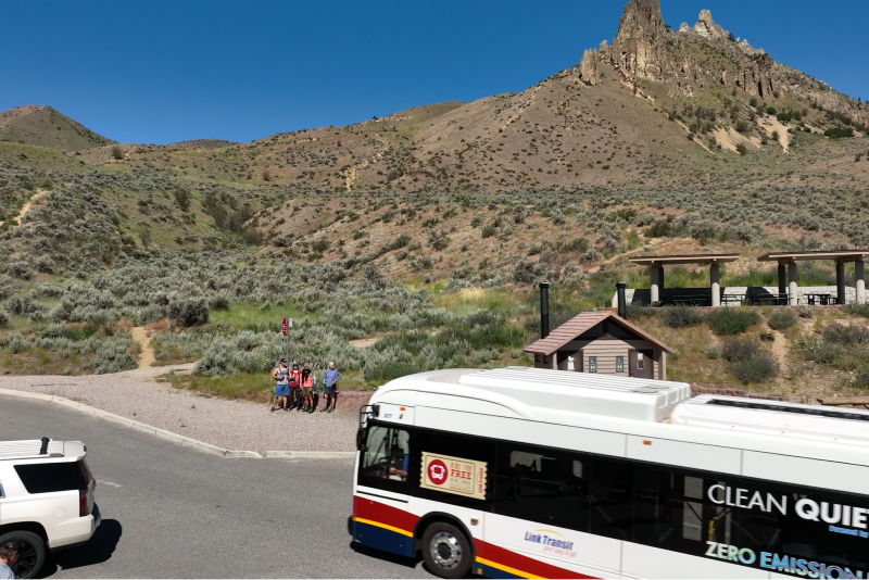 Zero emission bus stops at hiking trail with bathrooms