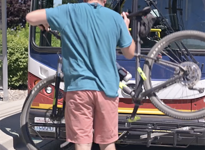 Guy loading bike onto bus