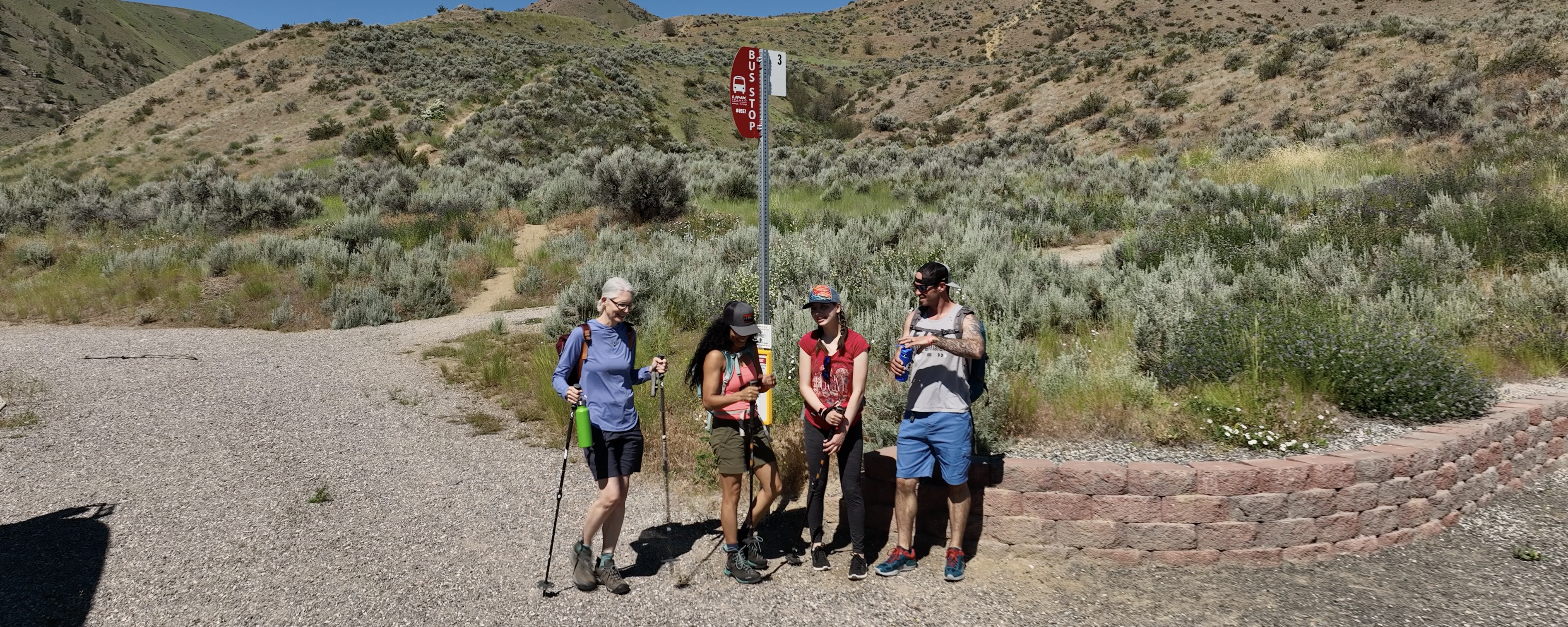 four hikes wait at a bus stop