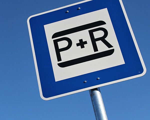 A park and ride sign against a blue sky.