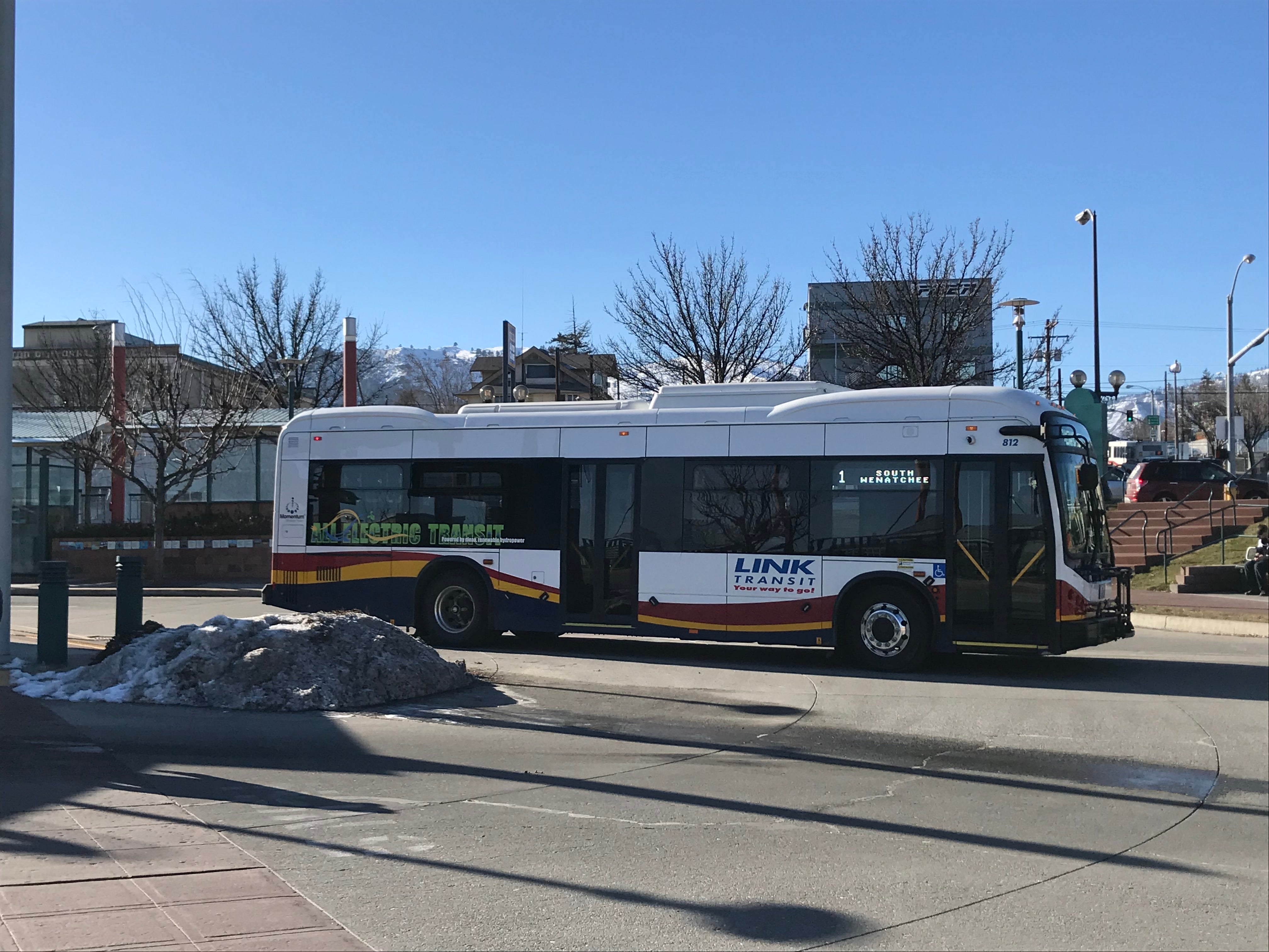 Link Transit electric bus with All Electric Bus written on the windows pulling out of Columbia Station